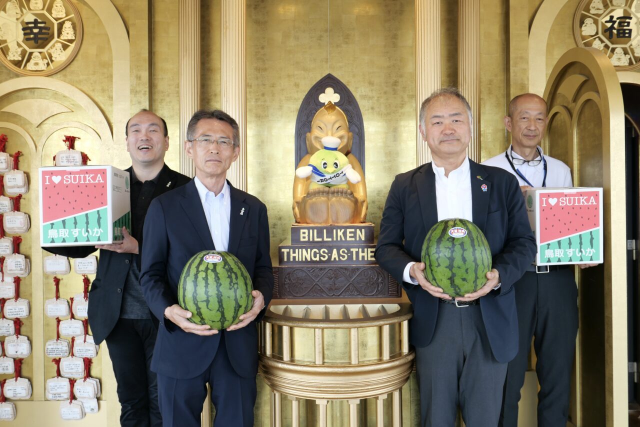 ビリケンさんに夏の味を奉納、鳥取県から通天閣にスイカ2玉が届きました。アニメ縁に地域交流