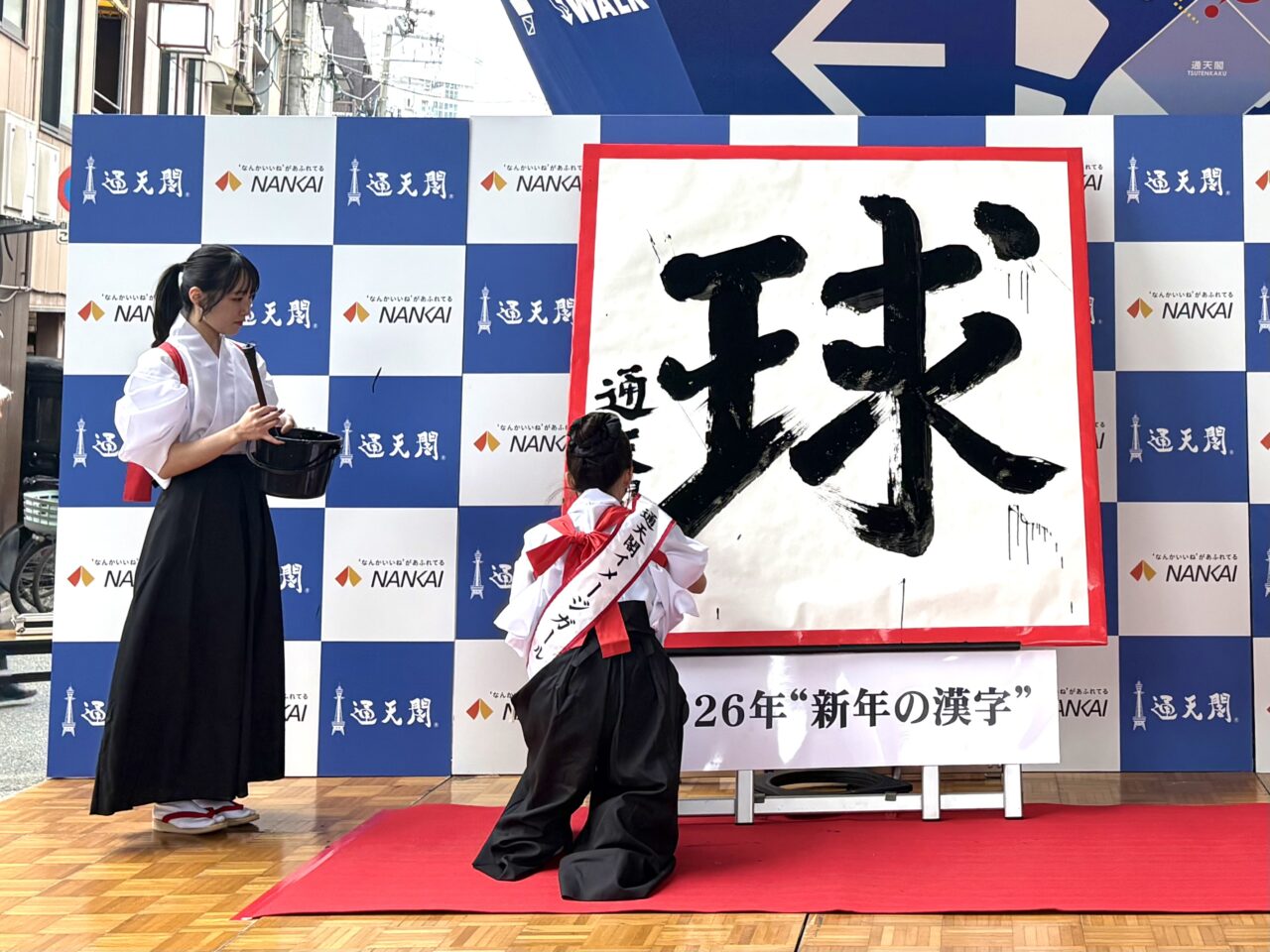 2026年の漢字は「球」、通天閣で新年の書き初め式と福米配りが行われました